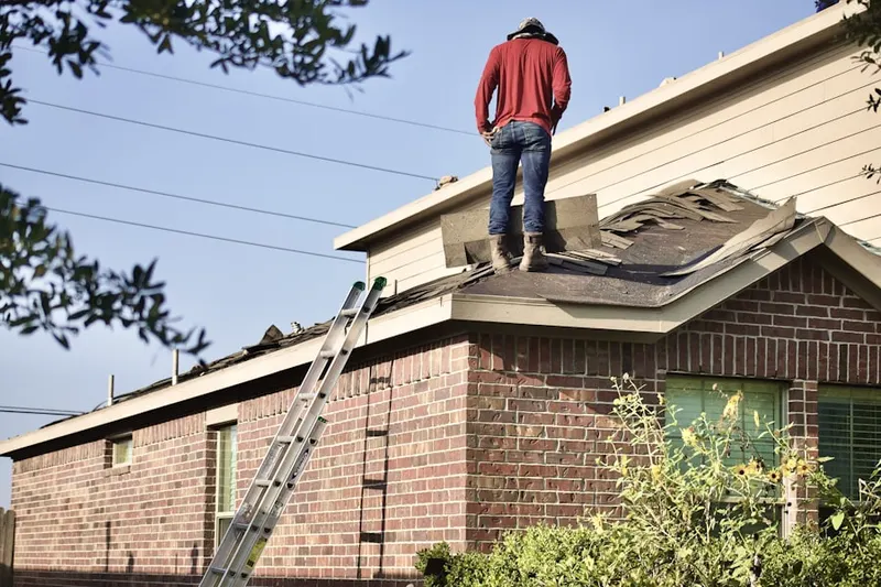 Professional roofer working on a residential roof in Bursonville